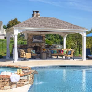 14 foot by 12 foot vinyl traditional pavilion with a fireplace and a pool nearby.