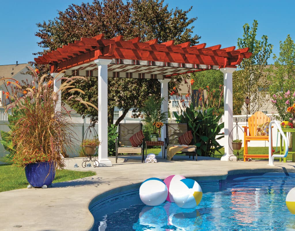 a pool with a covered patio and chairs with a pergola