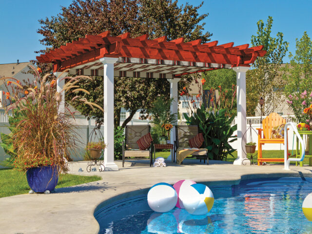 a pool with a covered patio and chairs with a pergola