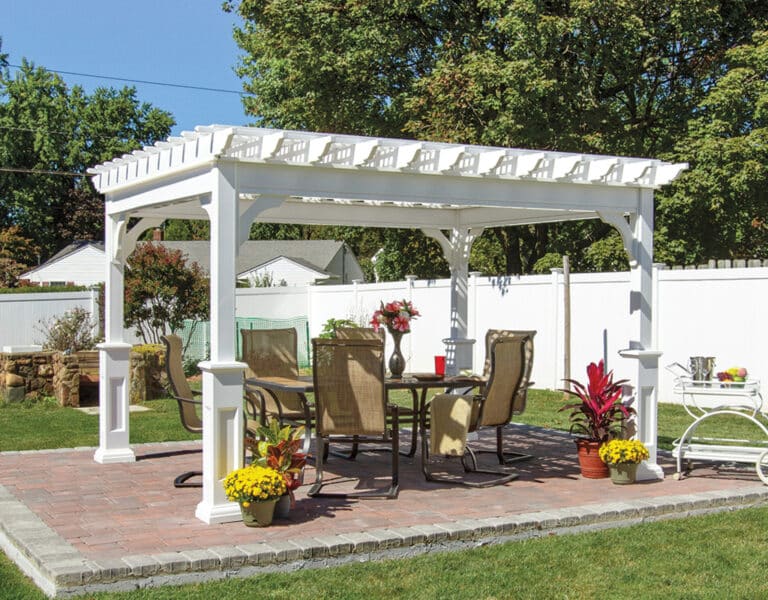 10'x12' Vinyl Traditional(A)_ a patio with a table and chairs and white pergola