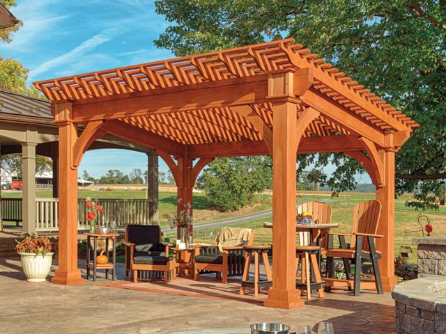 a wooden gazebo with a table and chairs under a fire pit