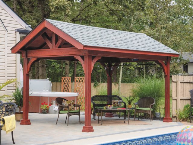 a covered patio with a hot tub and a table and a large wood pavilion