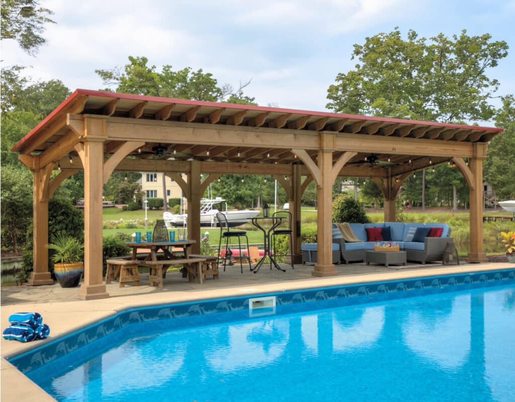 a pool with a covered patio and a table and pavilion