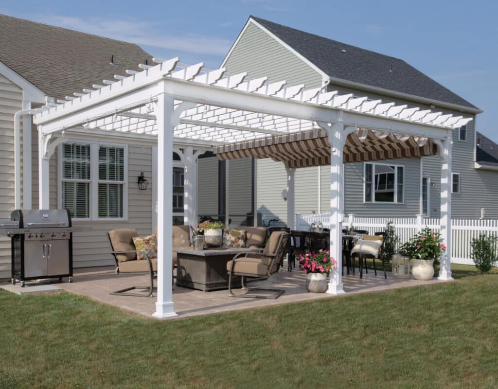 a patio with a table and chairs and a large white pergola