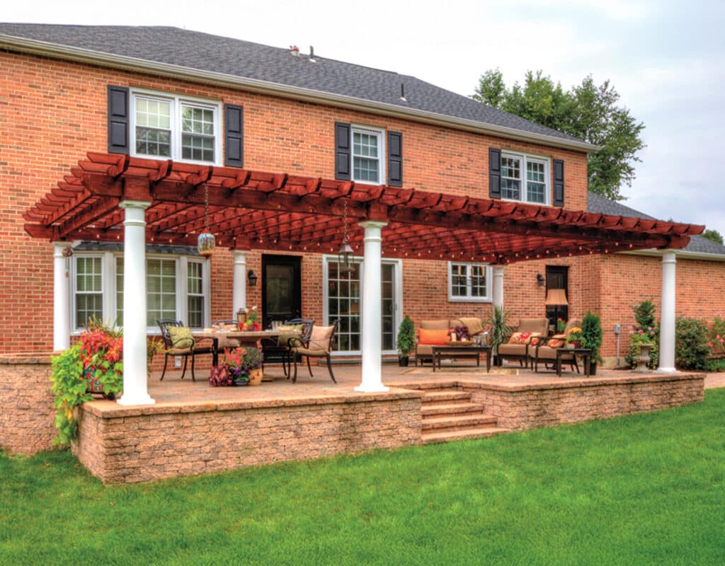 a patio with a covered patio and a lawn and a pergola with columns