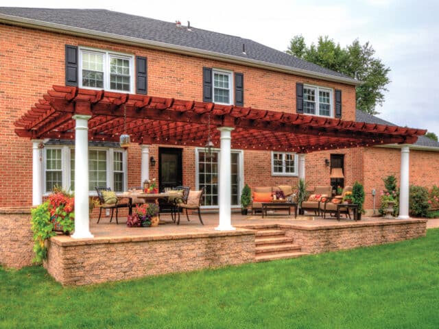 a patio with a covered patio and a lawn and a pergola with columns