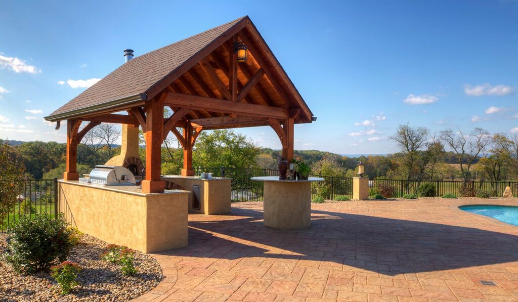 a gazebo with a wood roof and a grill