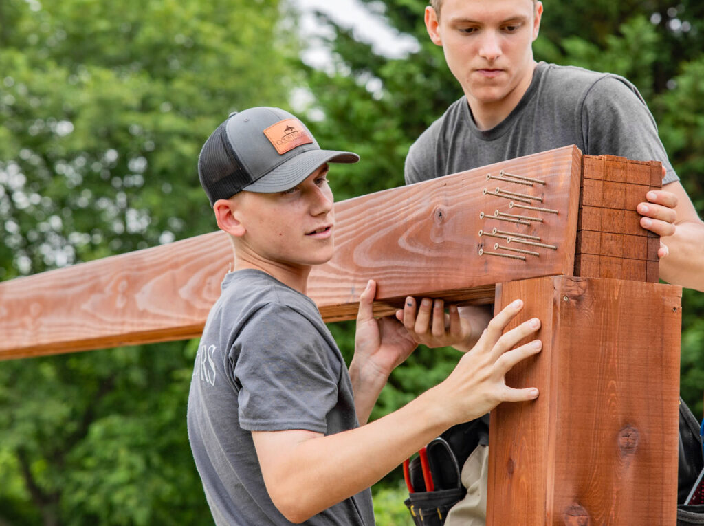 a group of men building a wood pergola or pavilion end cap