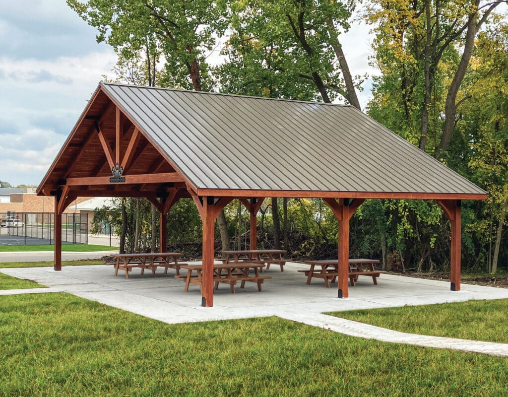 a picnic area with benches and tables and large pavilion custom