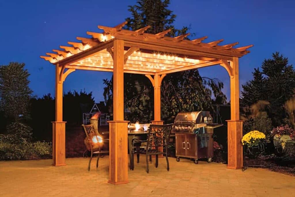 Pergola with string lights over a fire pit and grill